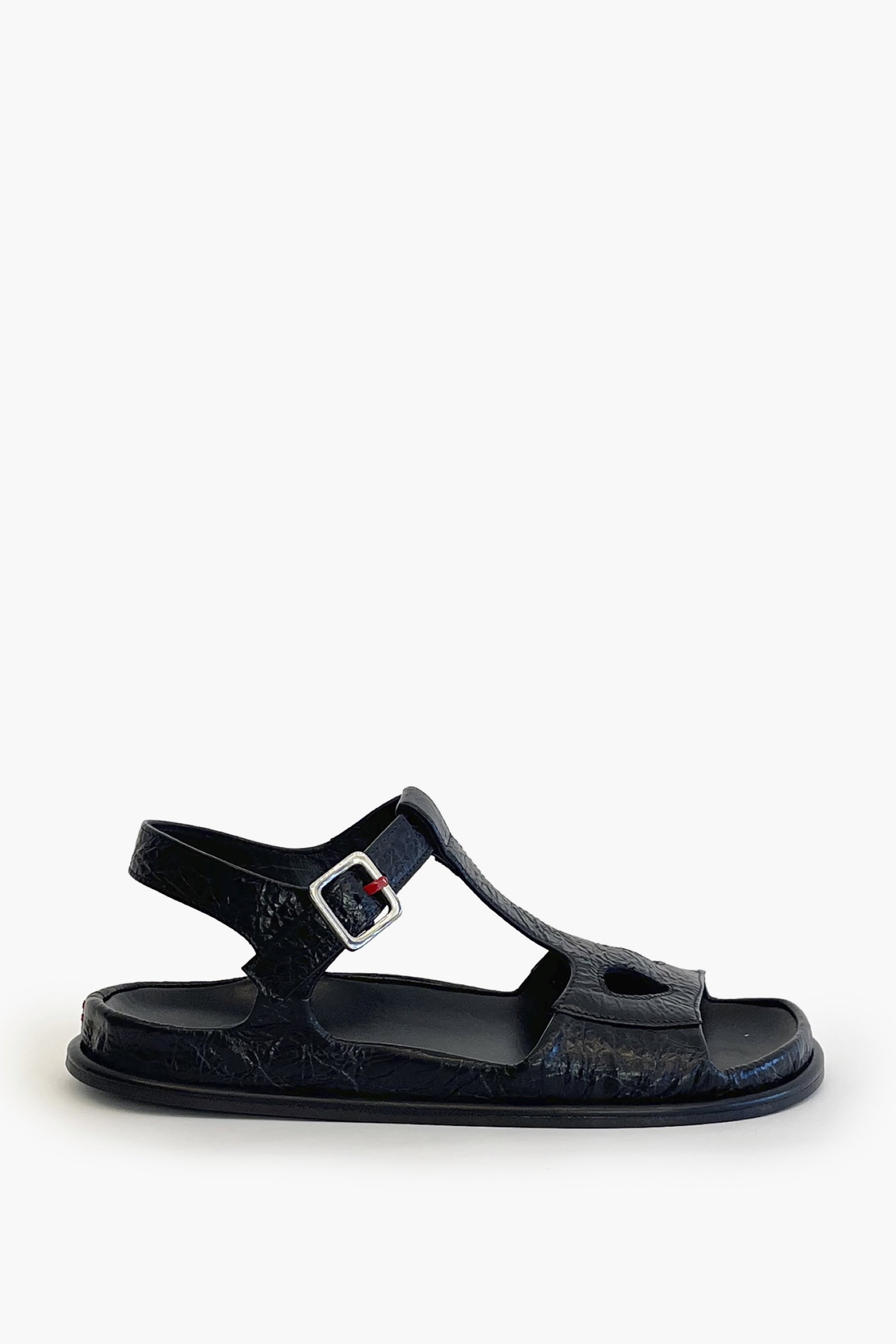 Black ankle strap flat sandal on a white background