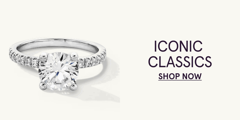 Solitaire ring with round-cut diamond, set on a pavé-set diamond band. Iconic Classics. Click here to shop now