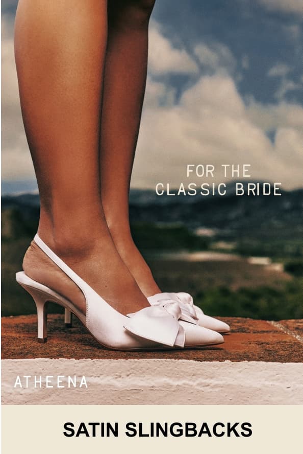 A close-up photo shows a person's foot wearing white satin "ATHEENA" slingback heels with a delicate bow detail. Overlaid white text on the right reads "FOR THE CLASSIC BRIDE", and the bottom text reads "SATIN SLINGBACKS".