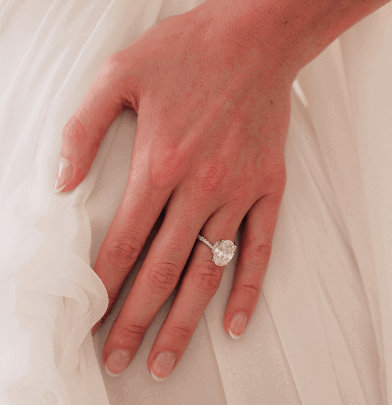 Bride wearing an oval engagement ring. 