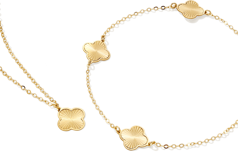 Gold necklace and bracelet with clover design. 