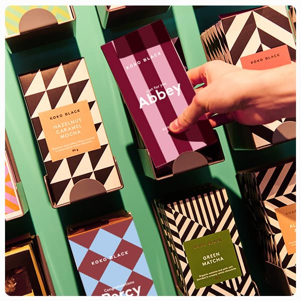 Hand reaching for a chocolate block with the name Abbey printed on it