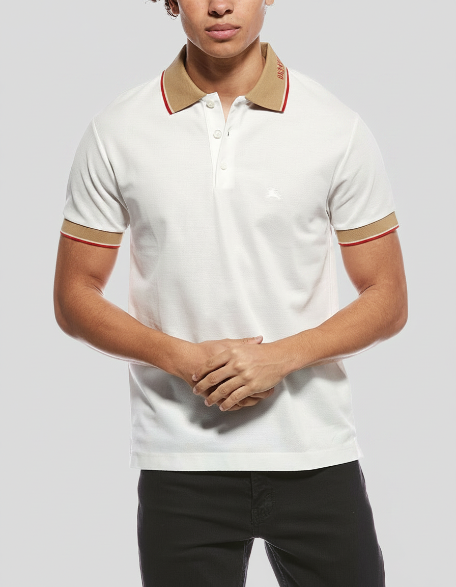 Man in a white polo shirt with tan and red trim, standing against a gray background.