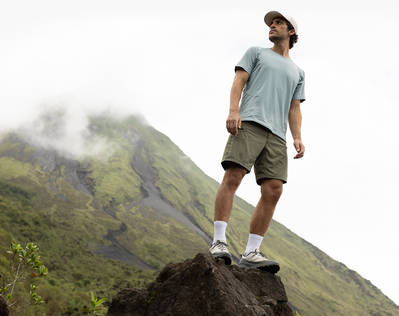 A man standing on a rock in front of a mountain