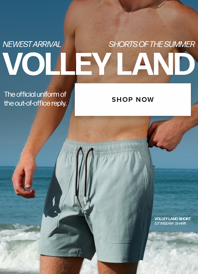 A shirtless man in blue shorts stands on a beach. Text reads: 'Newest Arrival Shorts of the Summer Volley Land The official uniform of the out-of-office reply. Shop Now Volley Land Short 5.5" Inseam - Shark'