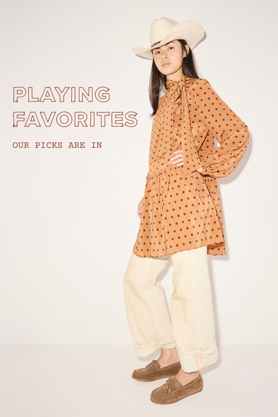 woman in orange dress with brown dots over khaki cuffed pants wearing brown suede loafers