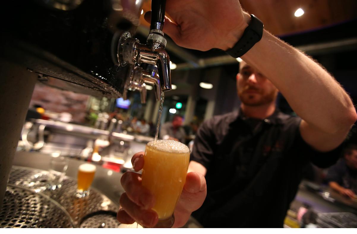  Bartender pours a beer from the tap