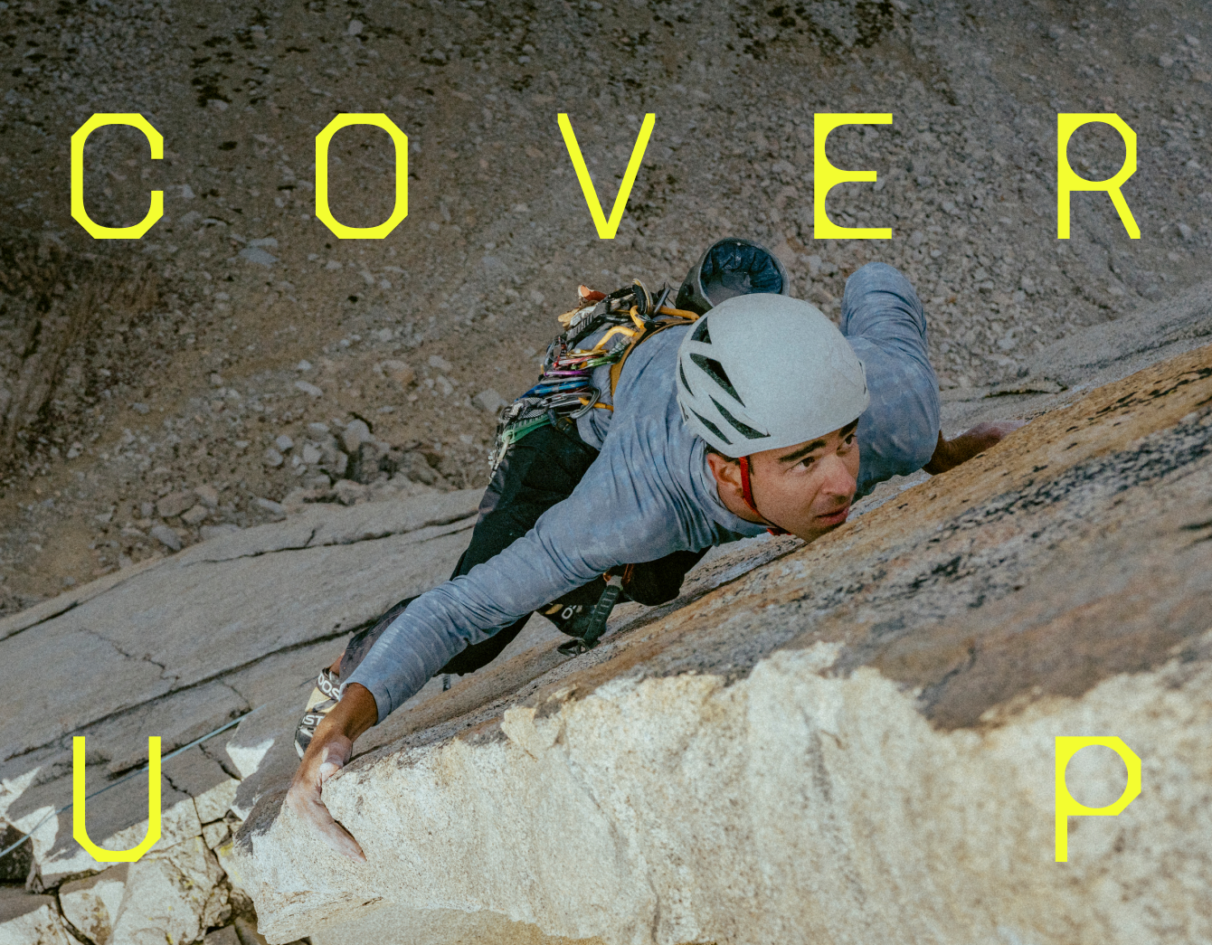 Cover Up / A climber sizing up the next hold.