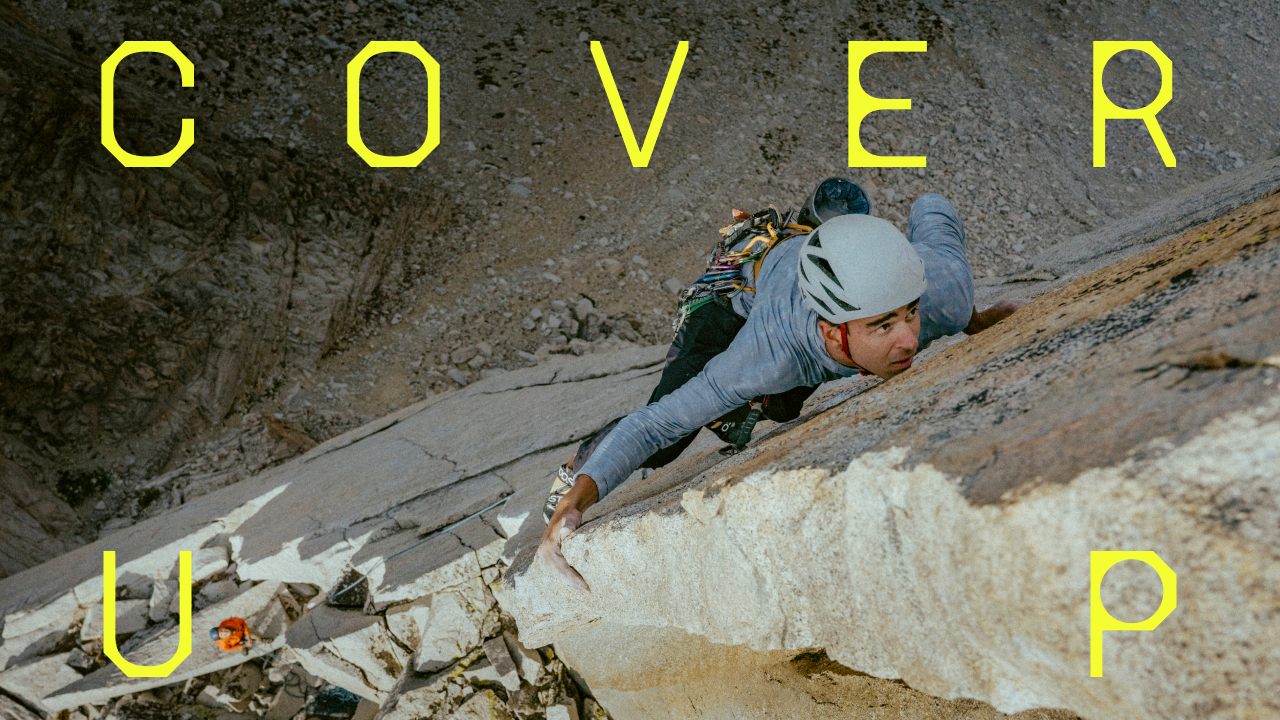 Cover Up / A climber sizing up the next hold.