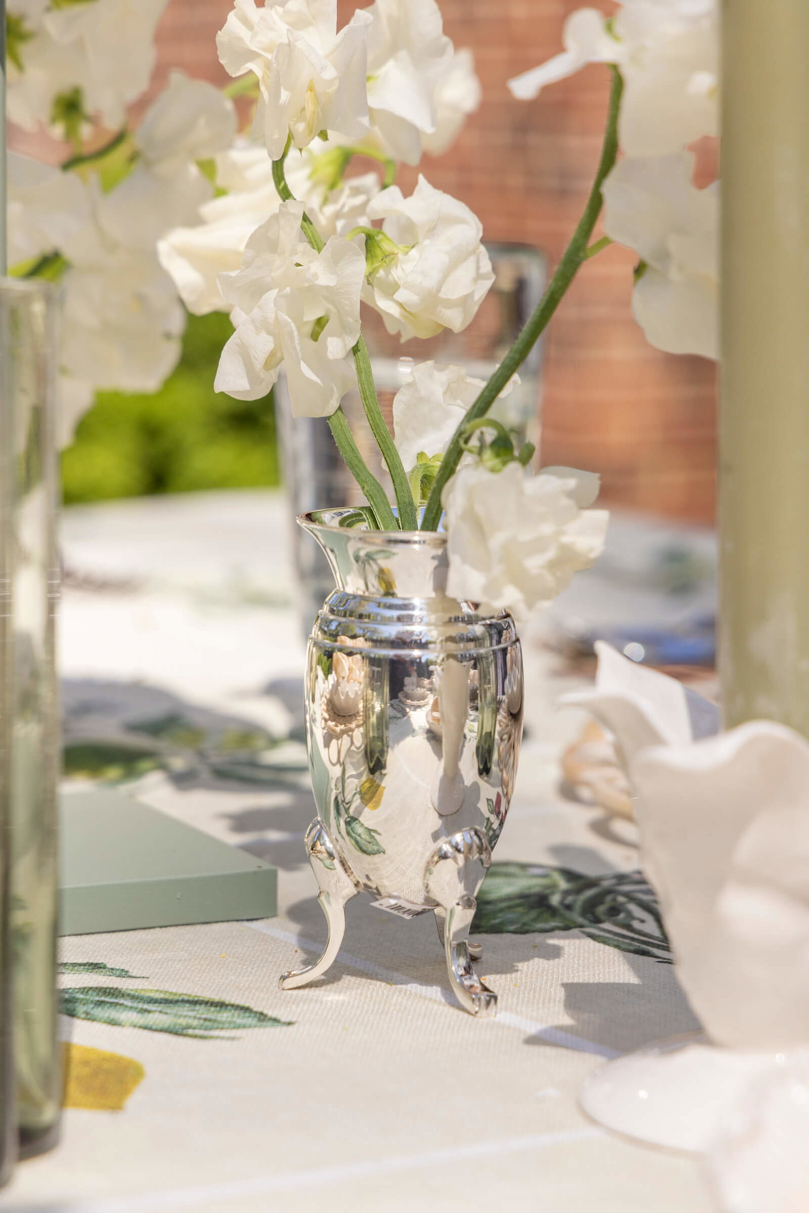 Queen Anne's Vase with white flower on table.