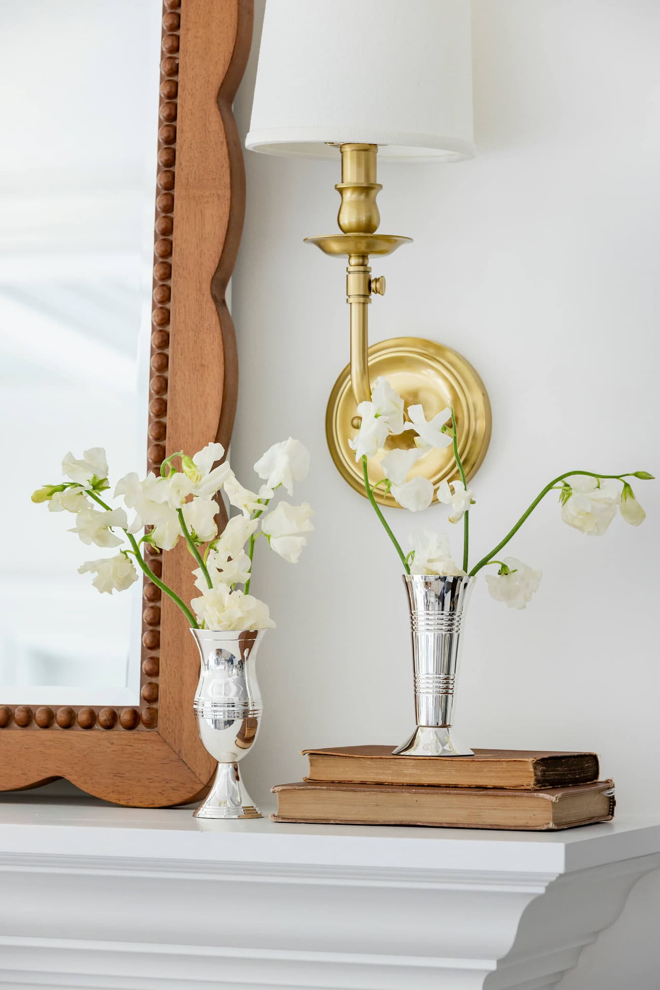 Two Queen Anne's Vases on mantle by gold sconce.