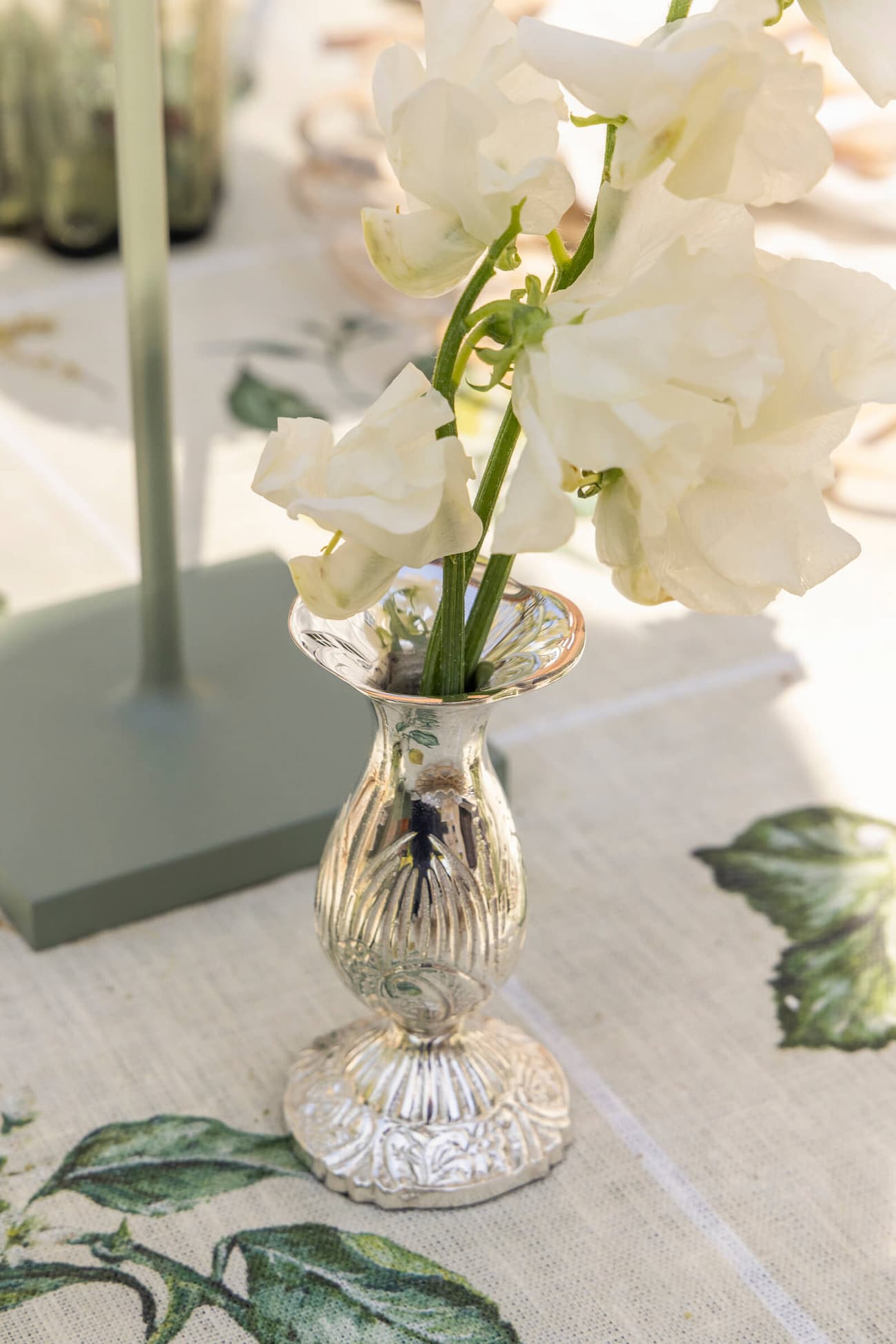 Queen Anne's Vase with white flowers on table.