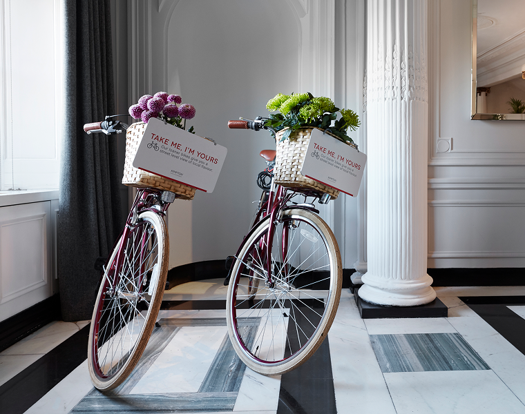 Two bikes with baskets attached to the front and signs that say “TAKE ME I’M YOURS.”