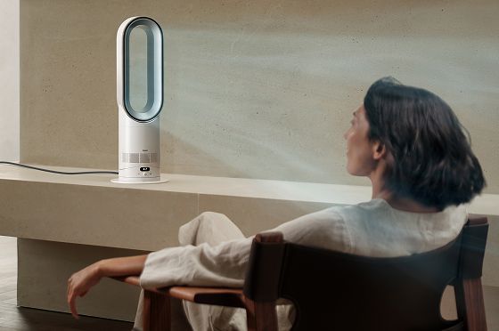 A person sitting while benefitting from focused airflow from a Dyson fan.