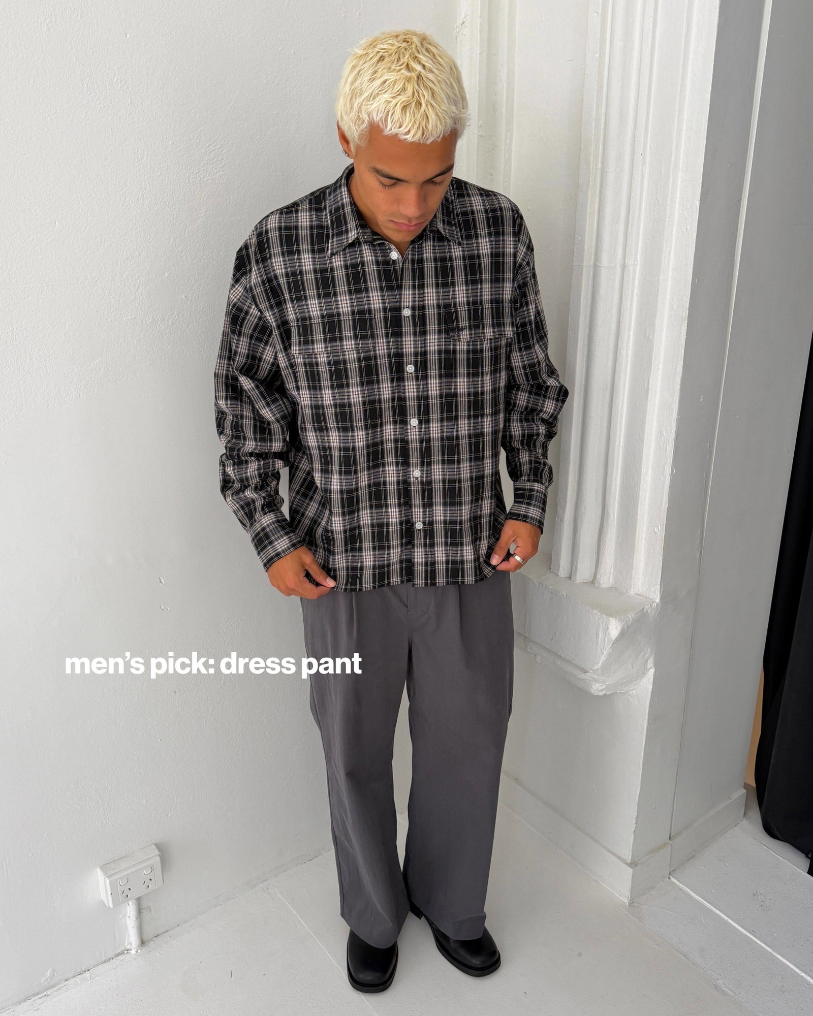 A medium shot shows a person with bleached blonde hair wearing a black and white plaid long-sleeved shirt and grey dress pants, with the text 'men's p...