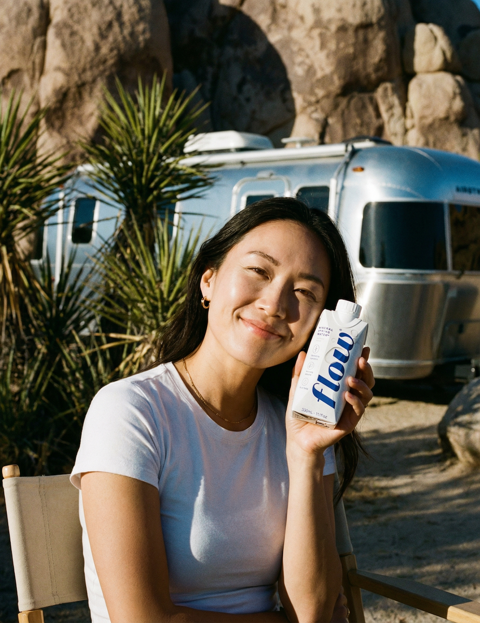 Woman holding bottle of Flow water