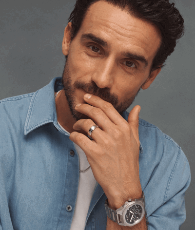 A dad wearing silver watch and wedding band. 