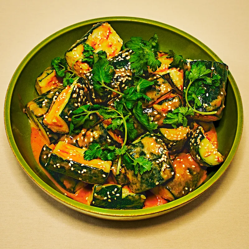 Smashed Zucchini With Tahini-Ginger Dressing in a green plate