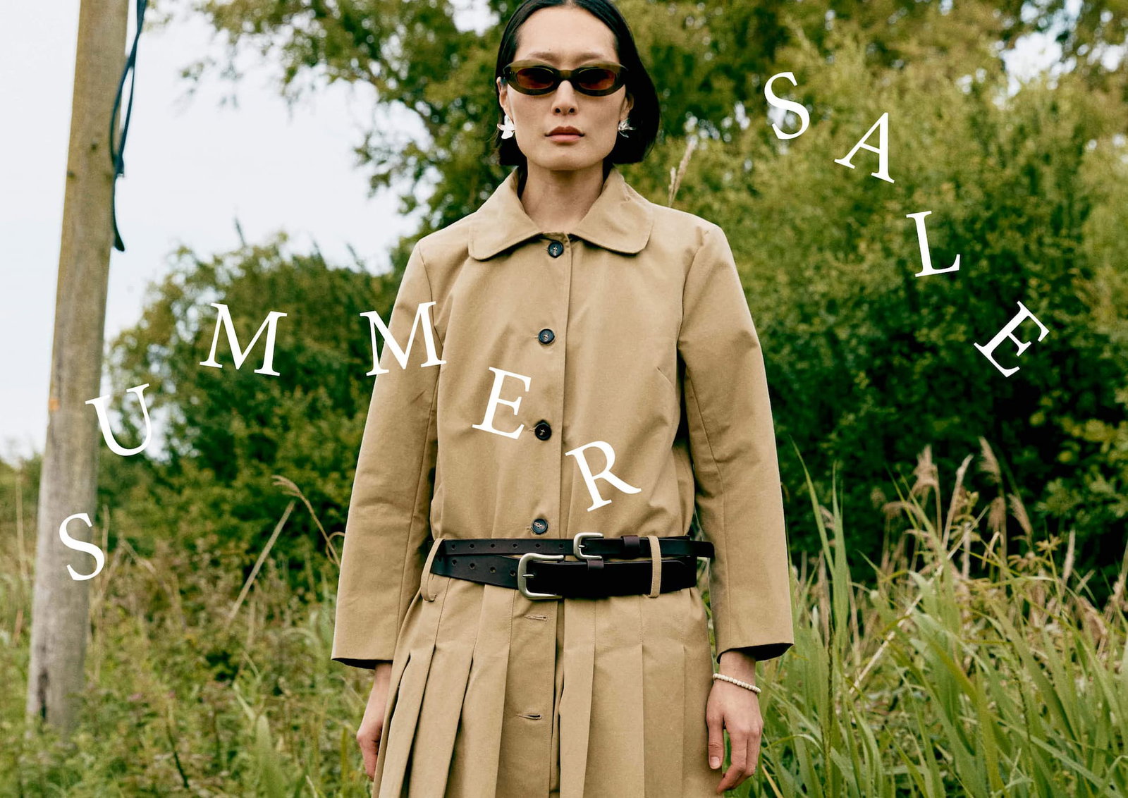 Woman wearing beige coat with "summer sale" text