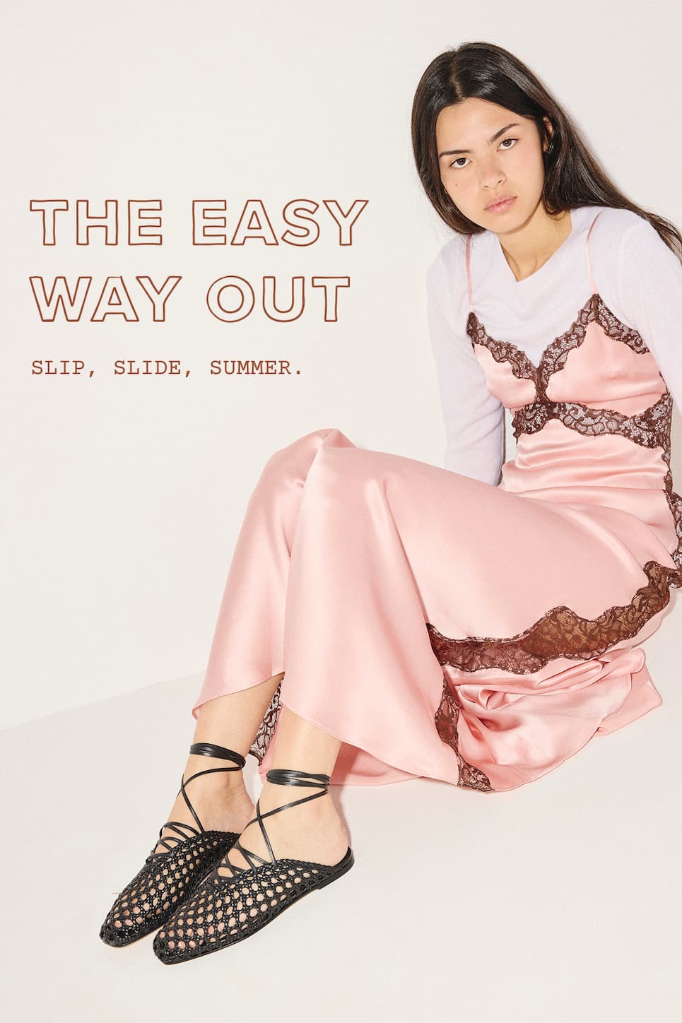 woman in pink silk dress with black woven slides with ankle ties