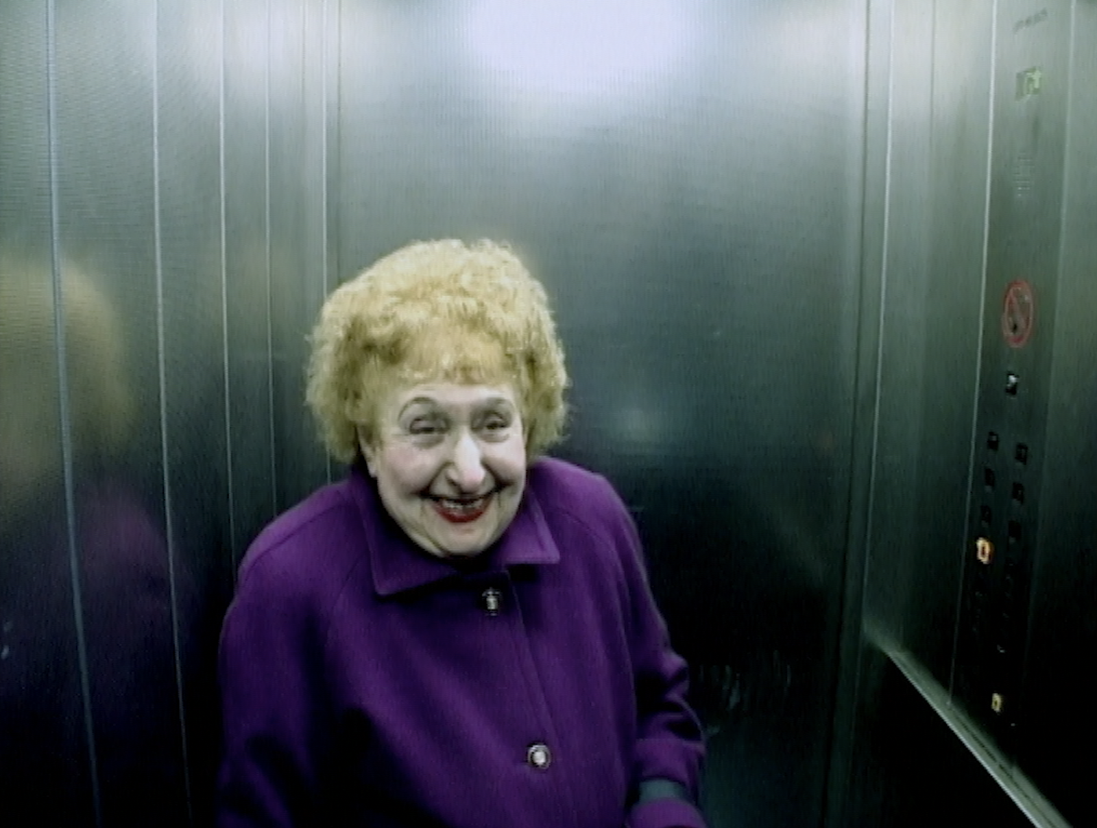 elderly woman smiling in a lift