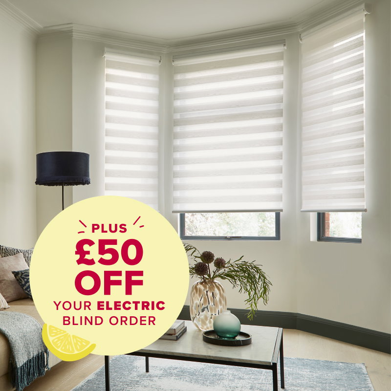 Three white electric roller blinds installed in a curved bay window of a modern living room