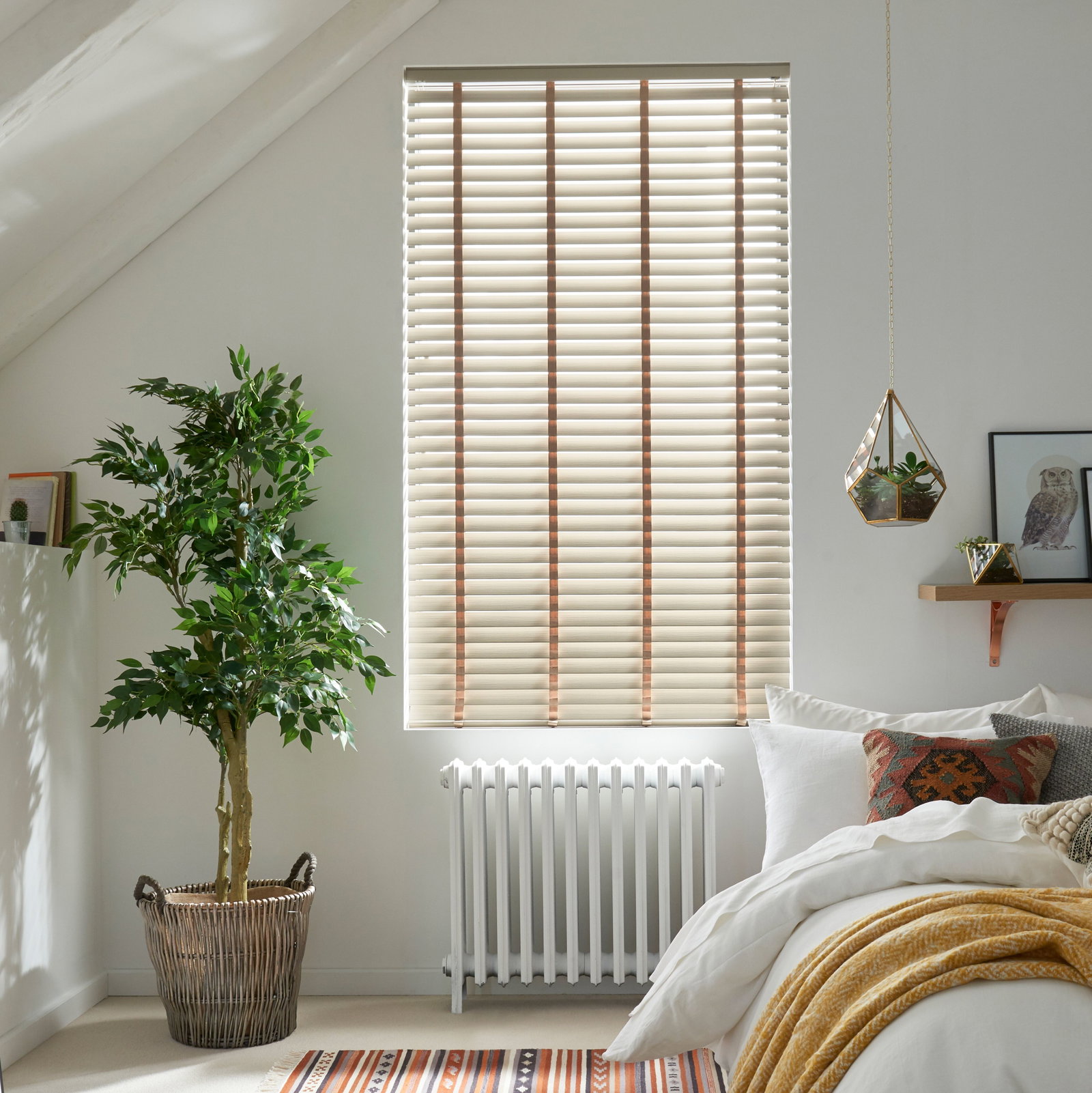  Light wood Venetian blinds with horizontal slats over a bedroom window