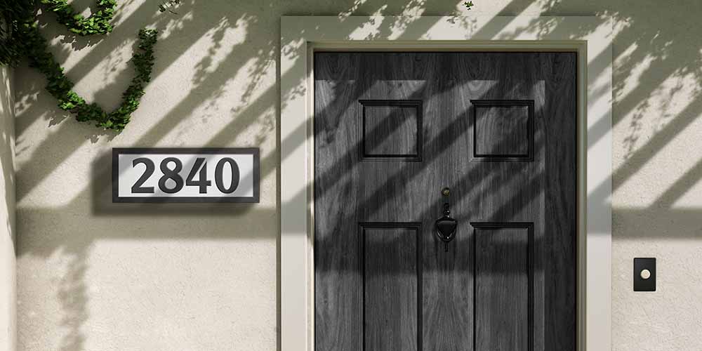 An International Style address sign next to a black door.