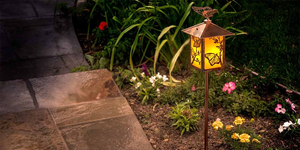 A garden light with butterfly artwork.