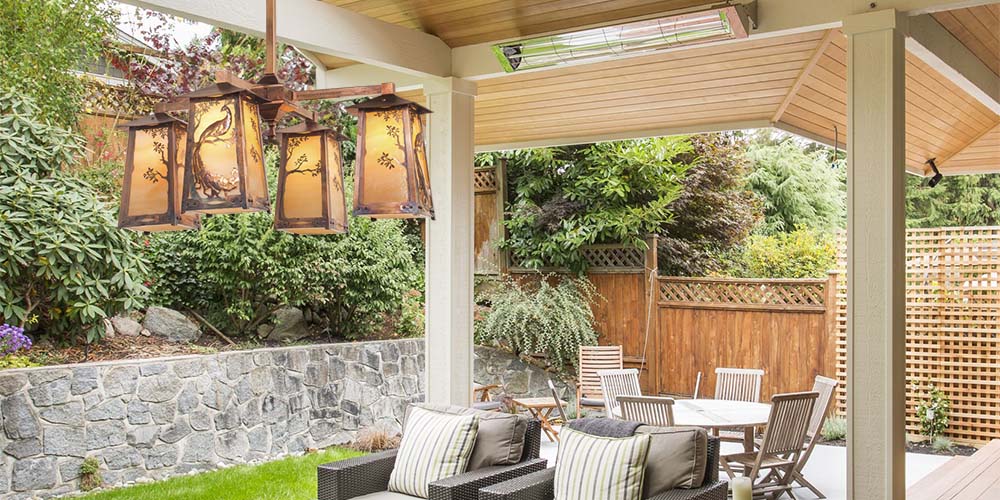 An Art Nouveau style outdoor chandelier under a covered porch.