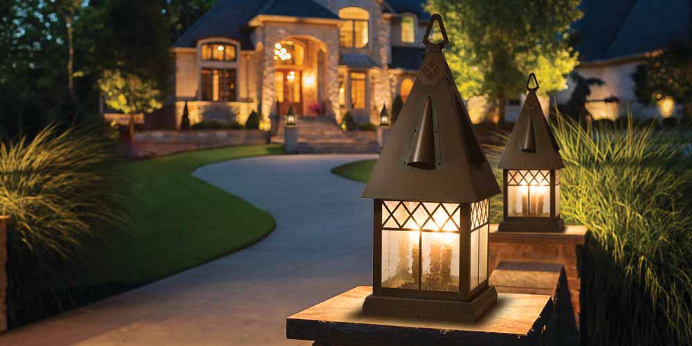 Tudor Revival column lights in front of a pathway and home.