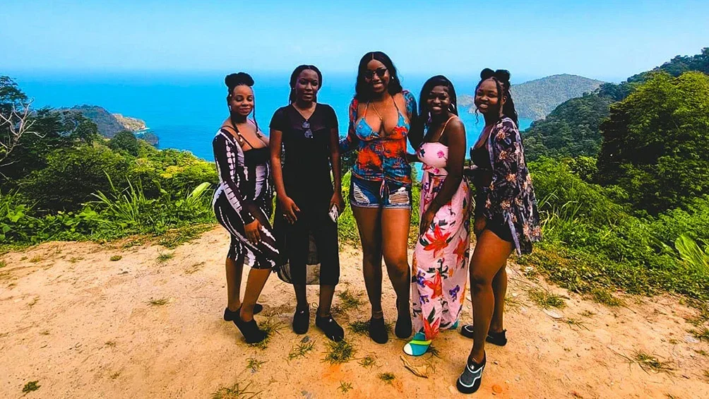 Image description: Group of friends posing for photo on a waterfall tour in Trinidad.
