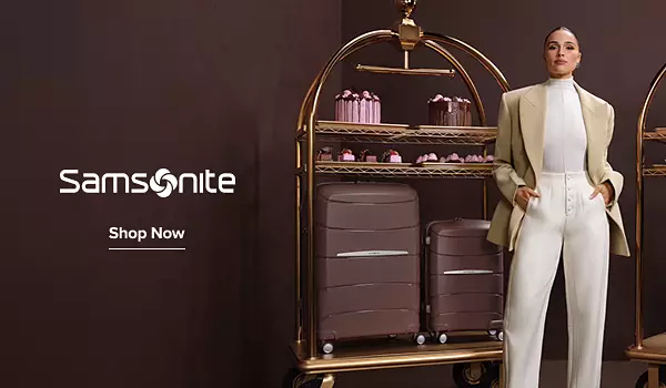 Image of a woman standing in front of a coordinating luggage collection on a luggage cart. Samsonite logo. Shop now.