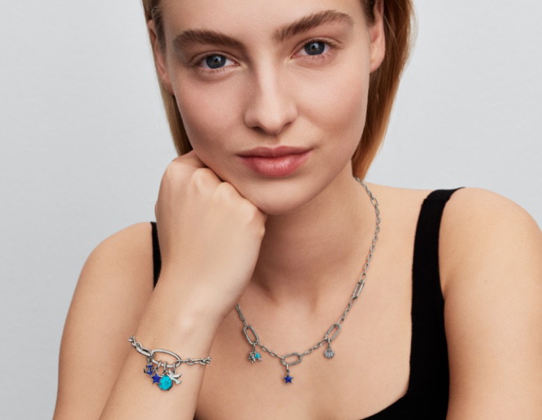 A model wears a sterling silver Pandora ME link chain bracelet and necklace with blue charms.