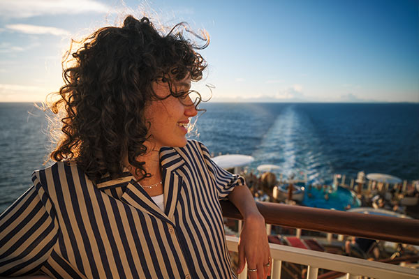 Person an Reling mit Blick aufs Meer und Schiffsdeck | Link zu AIDA 
