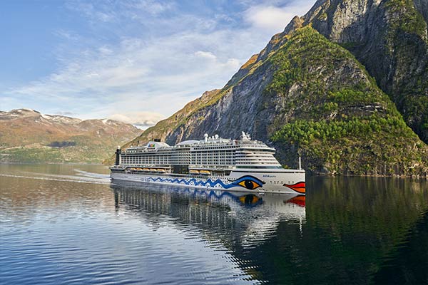 Kreuzfahrtschiff in ruhigem Fjord vor Bergen | LInk zu AIDA