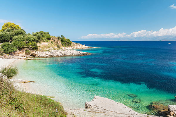 Türkisblaue Bucht mit Felsen und Strand | Link zu AIDA