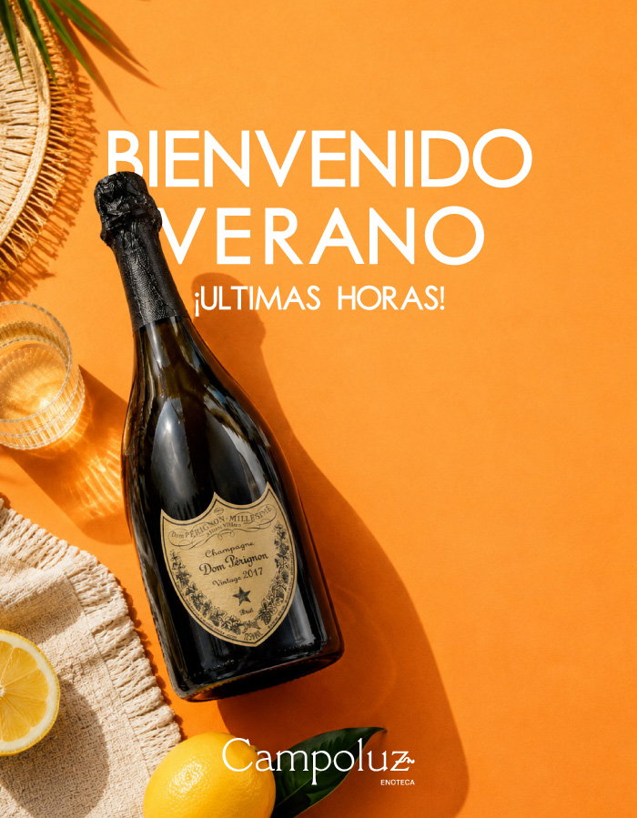 Vintage Dom Pérignon champagne bottle on orange background with glass, lemon, straw hat and 'Bienvenido Verano' summer text