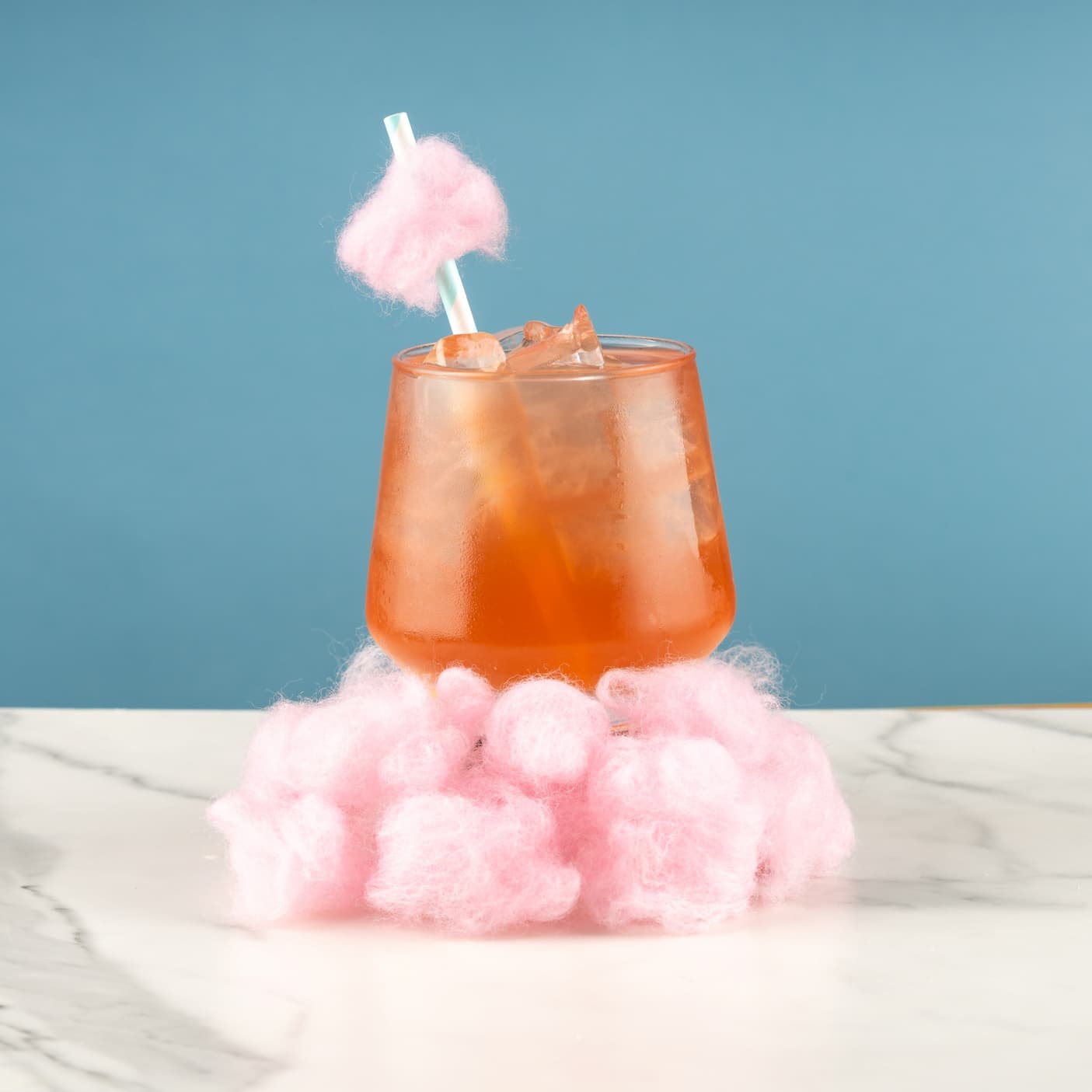 Cotton Candy iced tea surrounded by pink cotton candy
