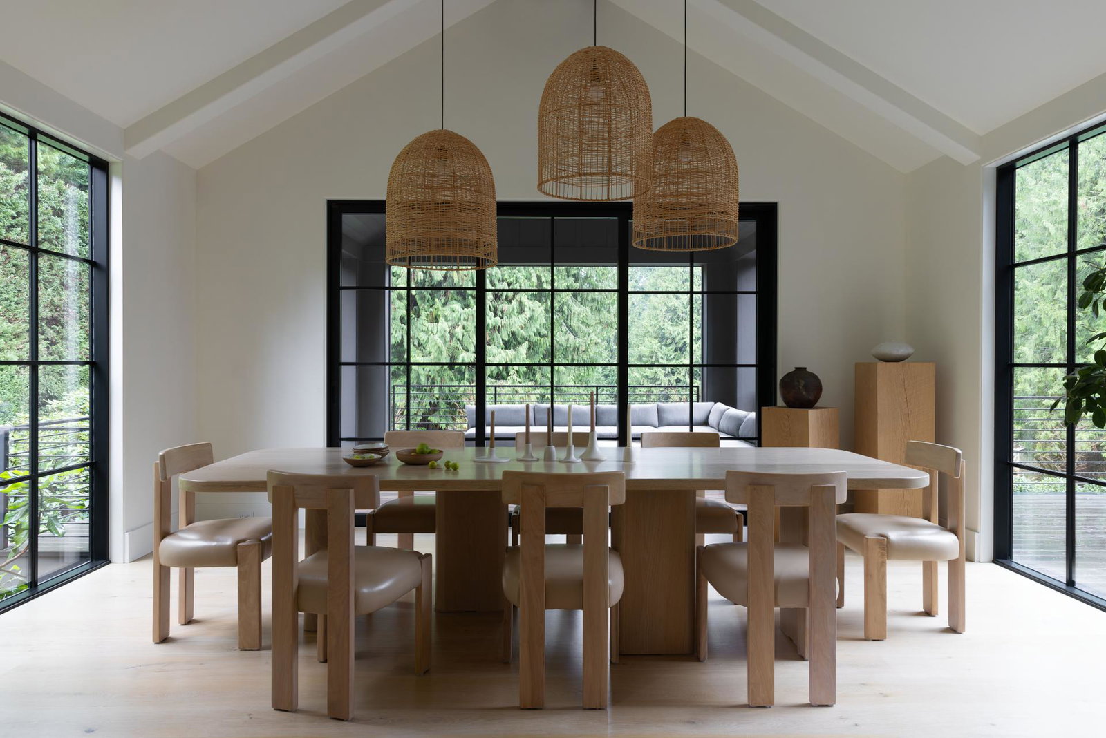 A dining room with large windows on three surrounding walls.