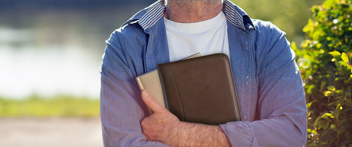 A person holding a brown leather planner cover
