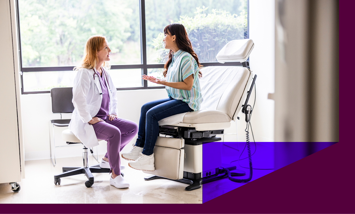 A doctor speaks with her patient in an office setting. 