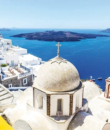 Whitewashed buildings and a domed church overlooking the deep blue sea in Santorini,