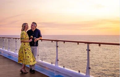 Couple relaxing together on the deck of a Marella cruise ship, looking out over the sea.