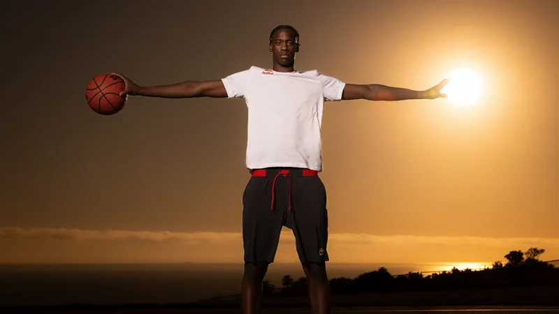 AJ Dybantsa posing with a basketball in front of a sunset