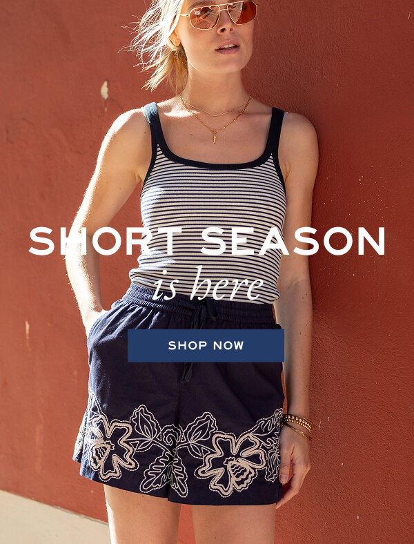 Short Season is here - Shop now - Image of a woman wearing a pair of navy shorts with white floral details.