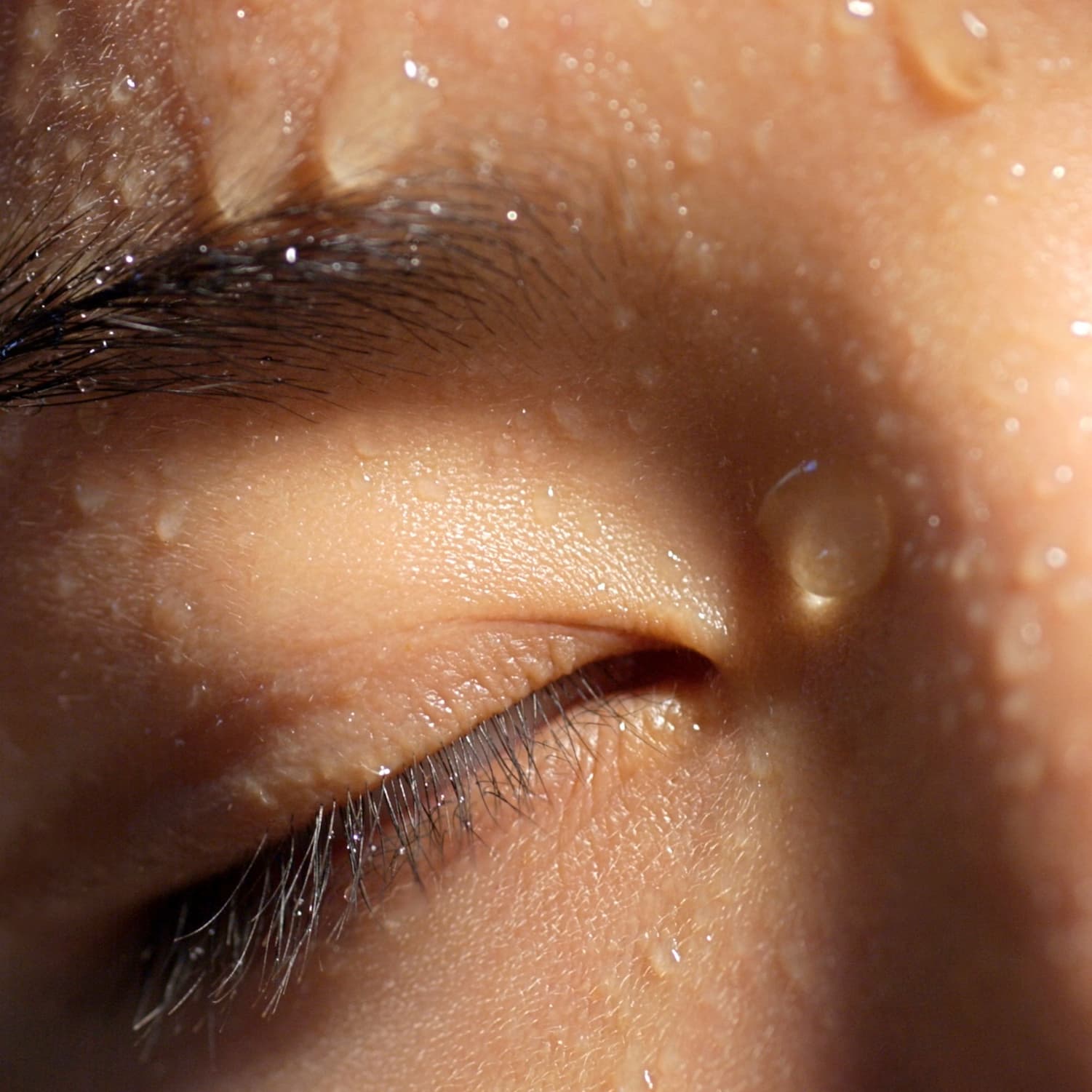 Close up of woman's eye, water drops on her face