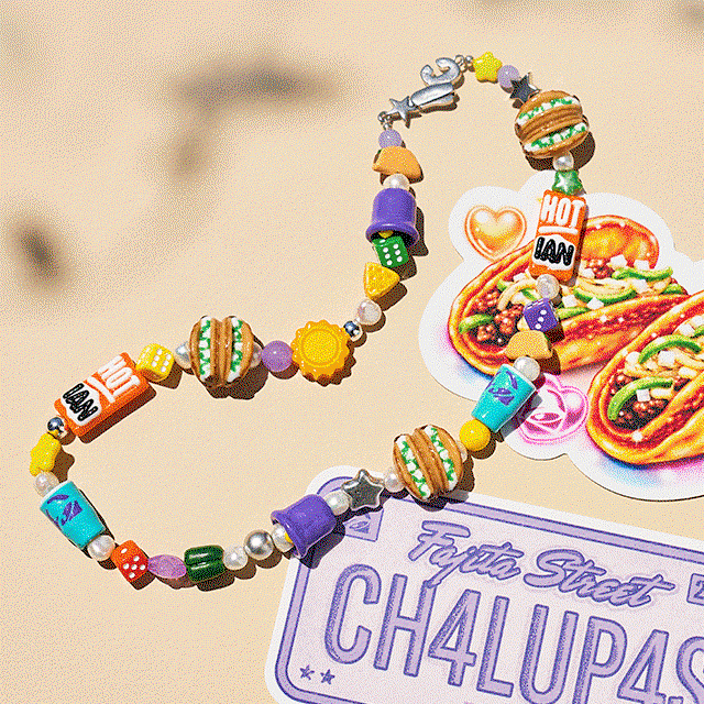 A colorful, custom charm necklace threaded with an eclectic mix of chunky, vibrant beads and distinct custom Taco Bell charms.