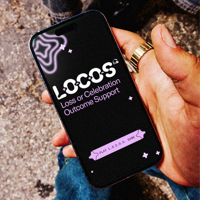 A person holding a mobile device with Taco Bell's L.O.C.O.S. game start screen.