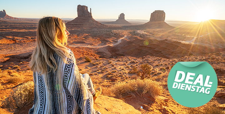 Frau sitzt vor dem Grand Canyon